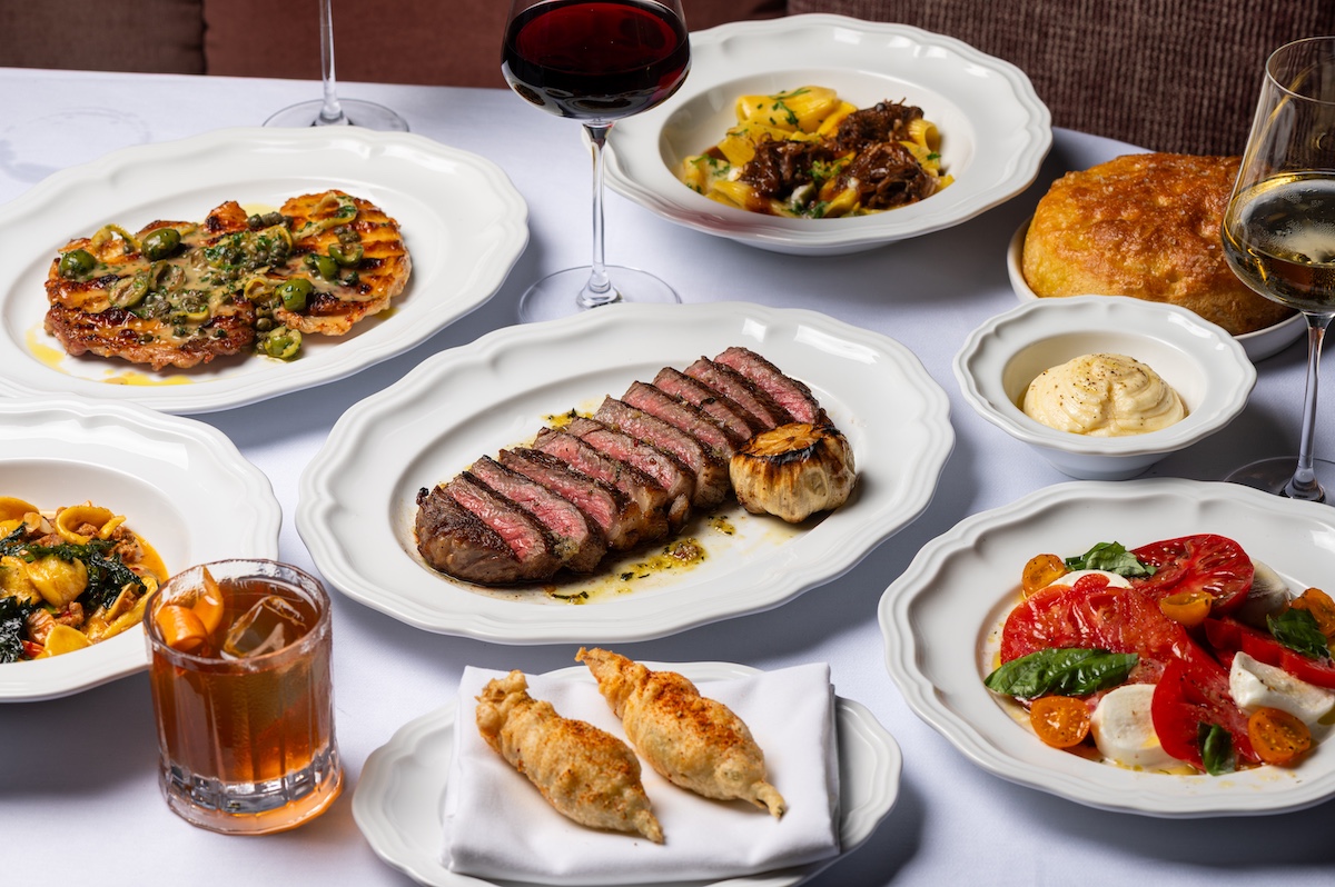 A spread of dishes from Marisella including bistecca, caprese, and pasta