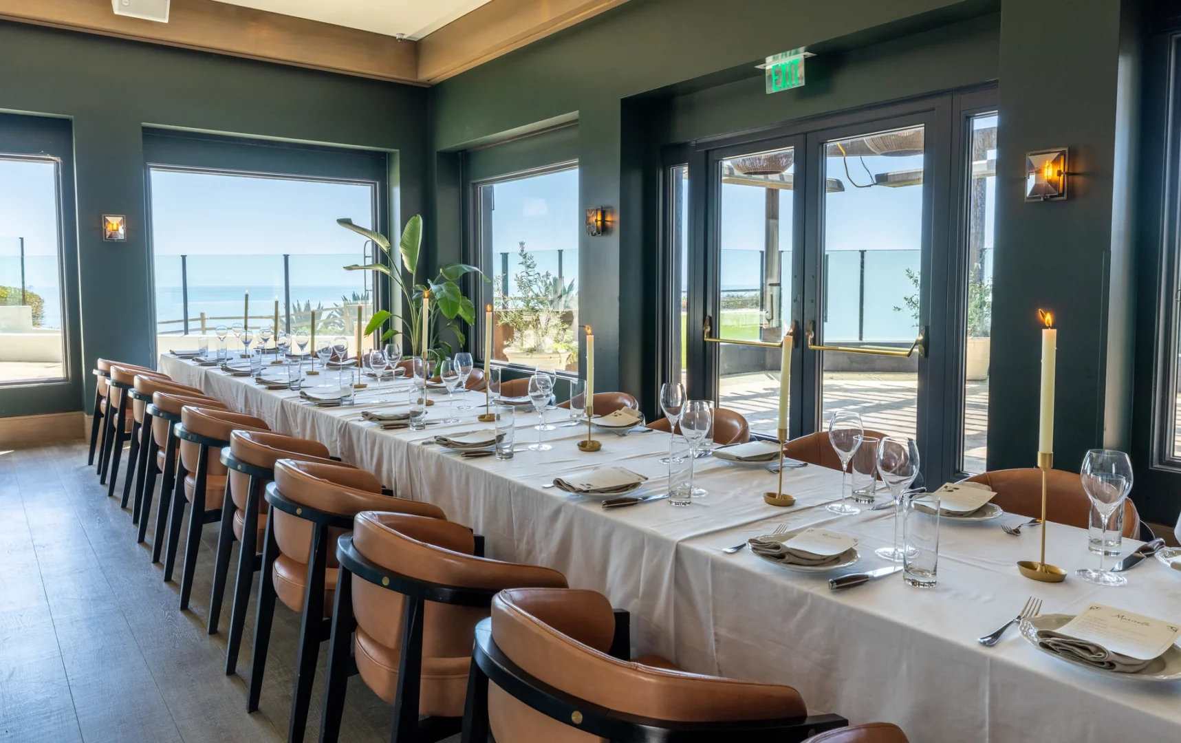 The dining room framed by windows overlooking the Pacific